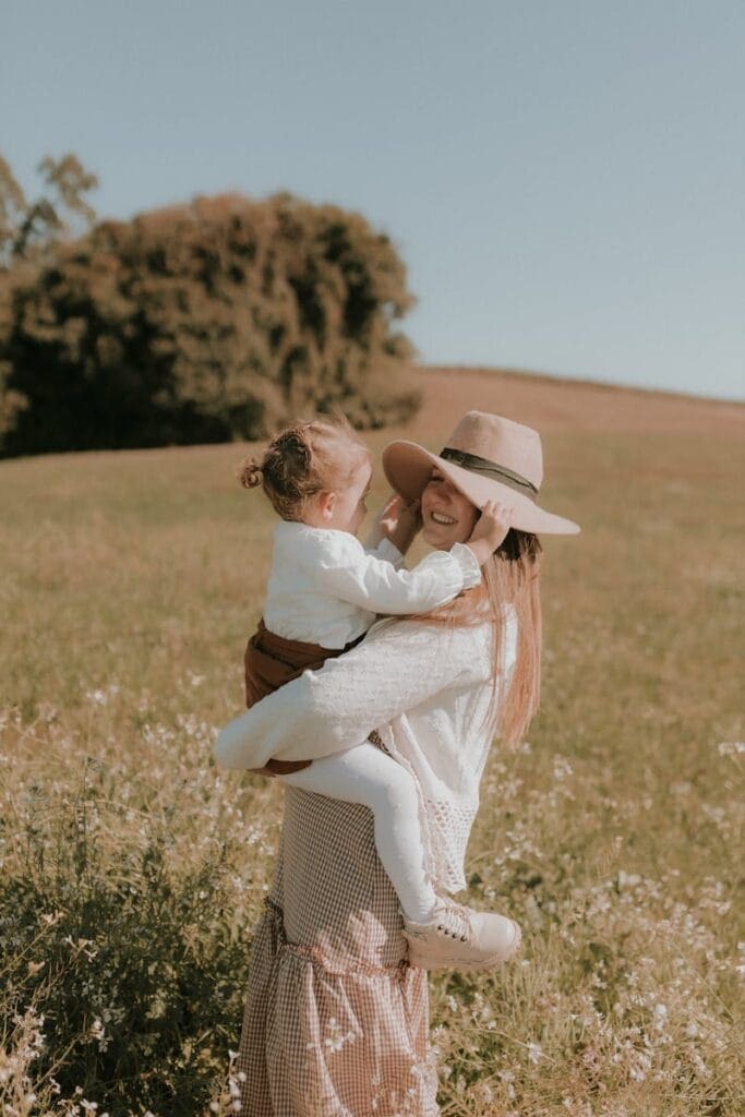 A woman holding her daughter in a field, happy after Gastric Band Hypnosis