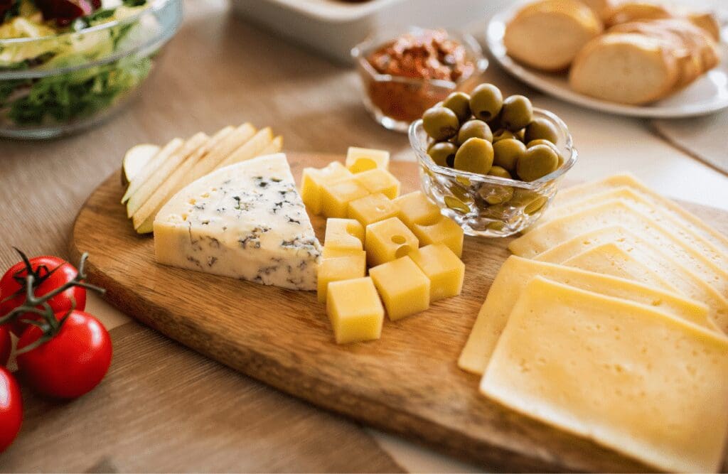 Various kinds of cheese on a wooden platter. Foods that cause inflammation. Brisbane Livewell Clinic