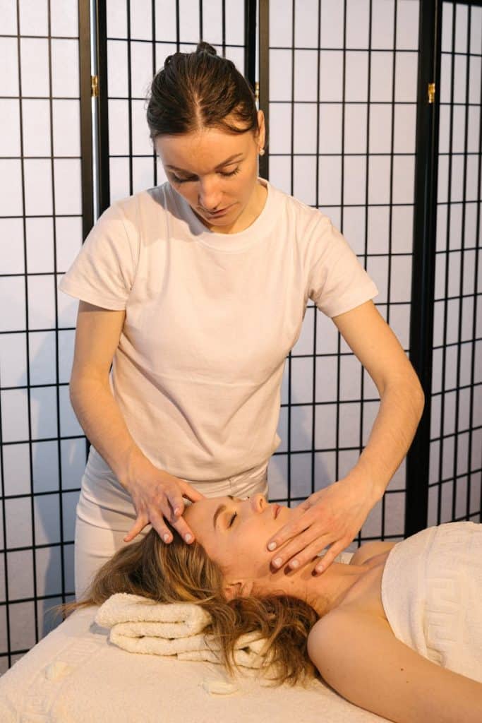 A Massage Therapist Massaging a Woman's Face. Massage. Brisbane Livewell Clinic