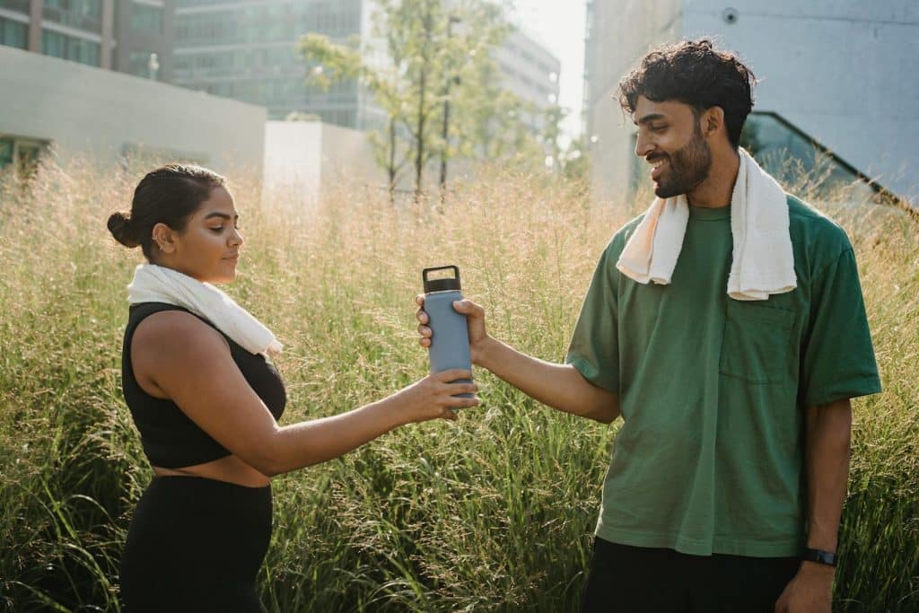 Man Handing a Woman a Water Bottle After Exercising representing Gastric Band Hypnosis at Brisbane Livewell Clinic