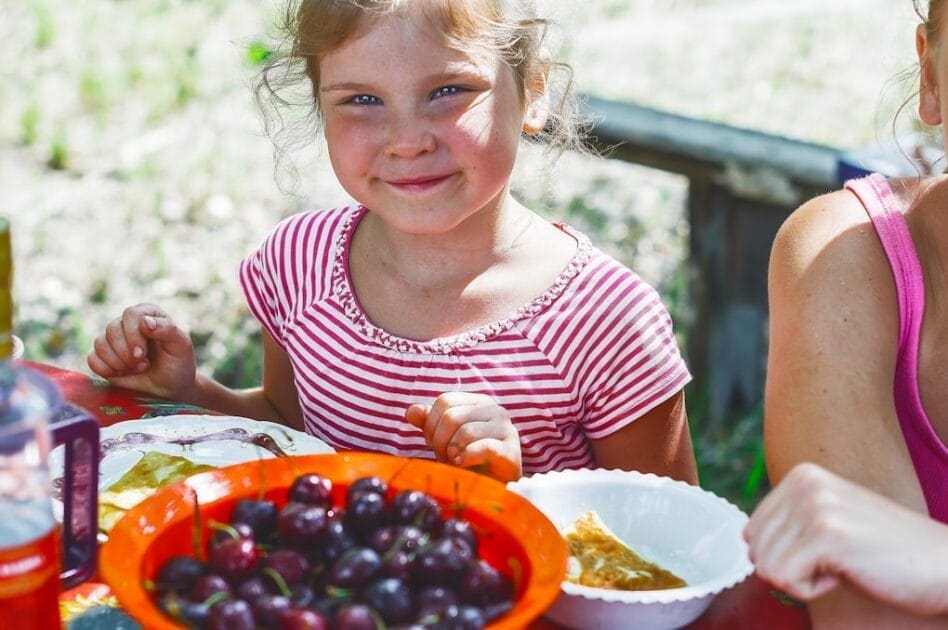 Girl in red and white striped shirt holding white ceramic bowl with grapes. Dietitian close by me. What is Leaky Gut?