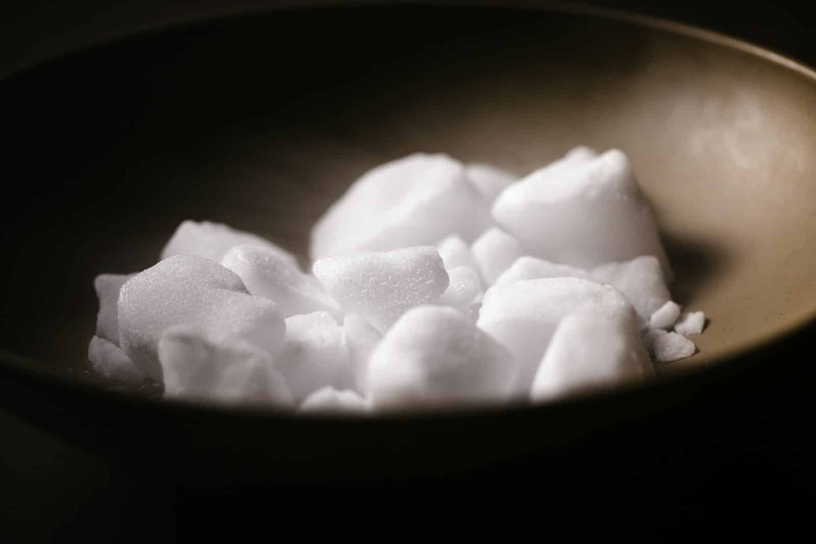 white sugar cubes in black bowl. Science of Sugar Addiction white sugar cubes in black bowl. Science of Sugar Addiction