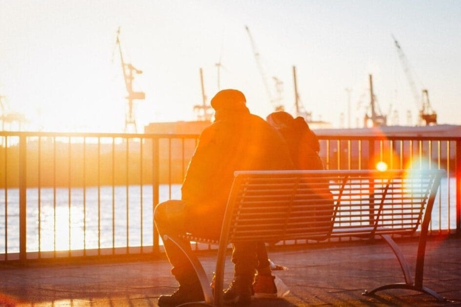 Two people sitting on a bench next to the ocean. Brisbane DNA Testing. DNA Test Brisbane