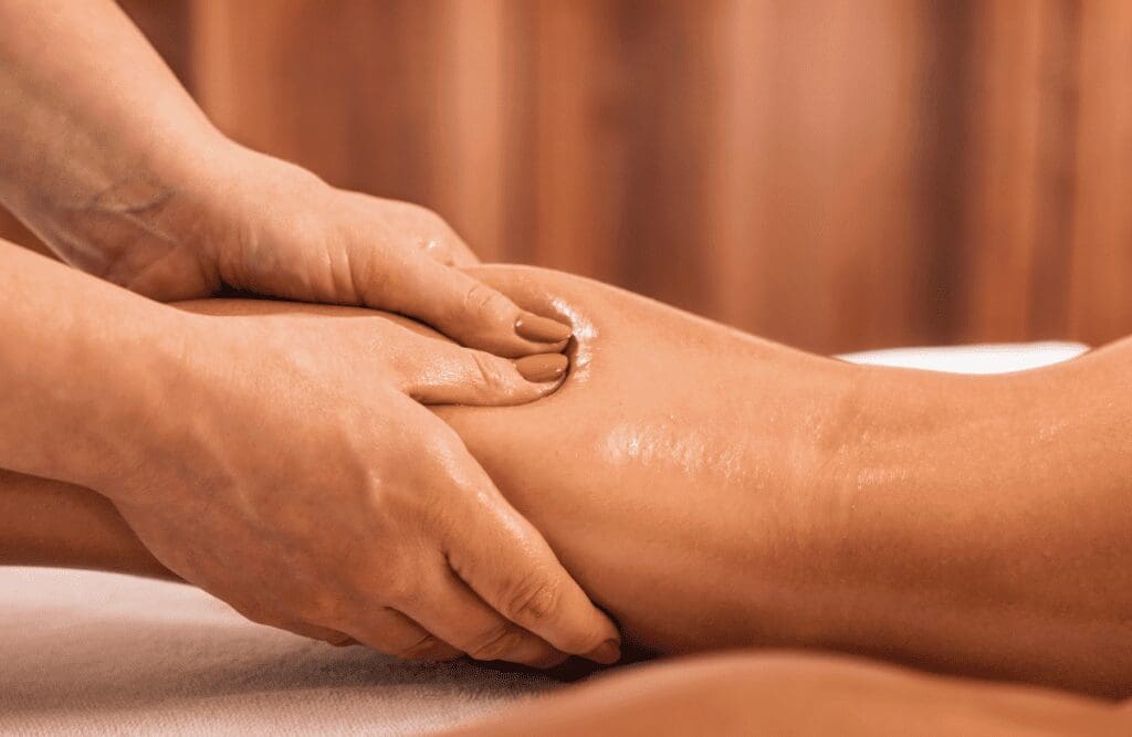 Massage therapist massaging the leg of a female client. Lymphatic Drainage Massage Brisbane. Brisbane Livewell Clinic