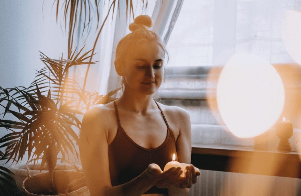 Woman holding a candle while doing self-care meditation. Successful detox. Brisbane Llivewell Clinic