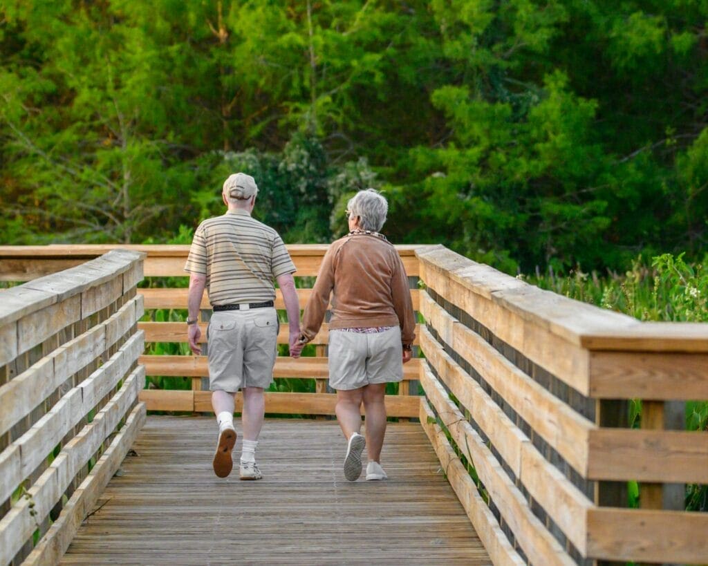 Older couple walking across a bridge. Naturopath near me. Osteopathy and Knee Pain. Brisbane Livewell Clinic