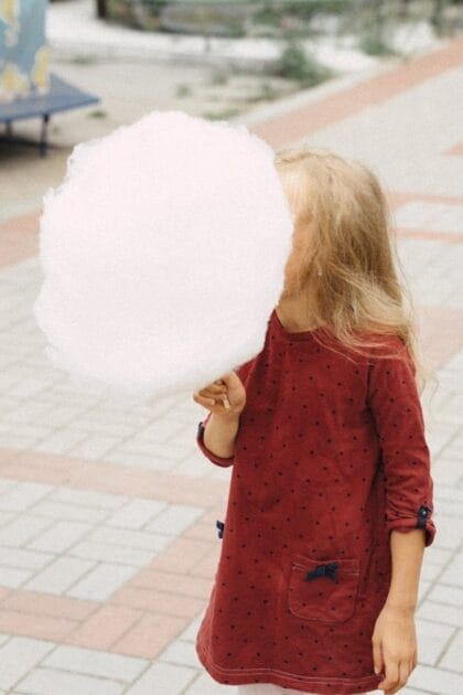 A little girl holding a large fairy floss - The Science Behind Sugar Addiction A little girl holding a large fairy floss - The Science Behind Sugar Addiction