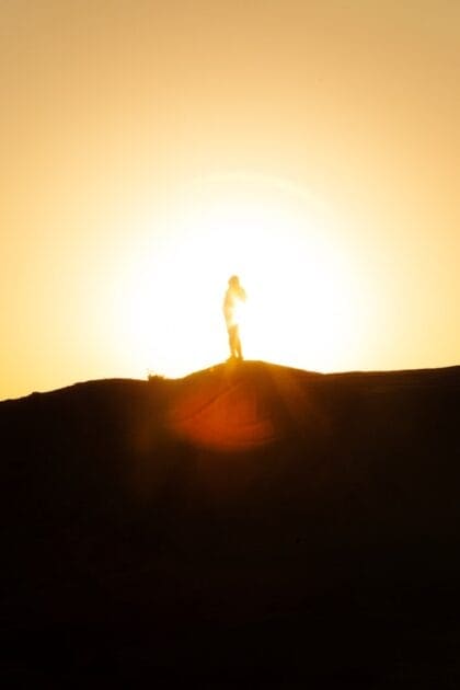 A person standing on top of a hill at sunset. Nicky Jackson / Nicole Jackson