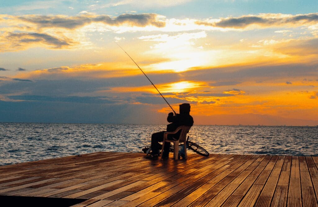 Silhouette of a person sitting on chair holding fishing rod near body of water. Naturopaths. What is Clinical Hypnotherapy. Brisbane Livewell Clinic