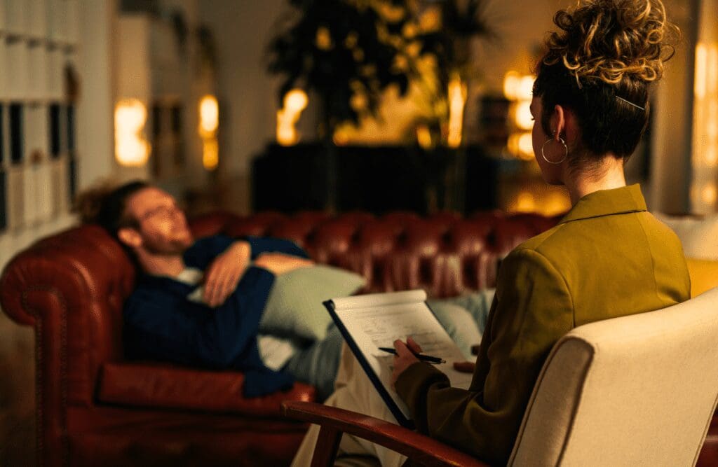 Man lying down on the couch for his Hypnotherapy session. Hypnotherapy FAQs. Brisbane Livewell Clinic