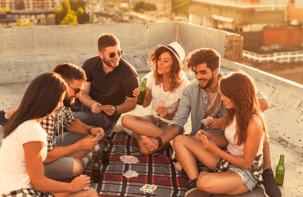 Friends playing cards on the rooftop. Hypnotherapy Facts. Naturopaths Brisbane Northside. Brisbane Livewell Clinic