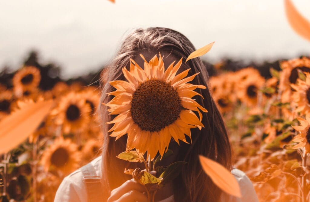 Woman covering her face with sunflower. Food Allergy Testing Near Me. Brisbane Livewell Clinic