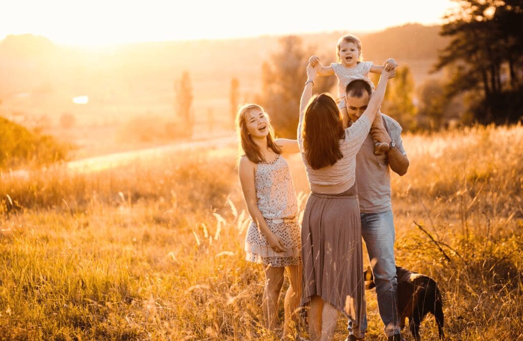 Family having fun together with their dog in a summer field. Iridology. Brisbane Livewell Clinic. Best Naturopath Near Me. Best Naturopaths Near Me. Naturopath Brisbane.