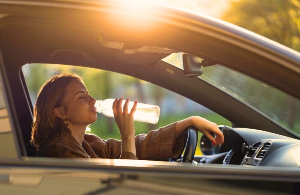 Woman drinking water in the car. Fitness Tips for Women. Menopause. Brisbane Livewell Clinic