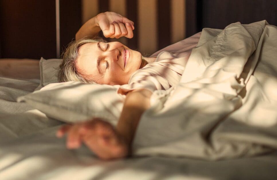 Woman happily wakes up from a good sleep. Happy Menopause. Naturopath for Insomnia. Menopause. Osteopathy and Better Sleep. Brisbane Livewell Clinic