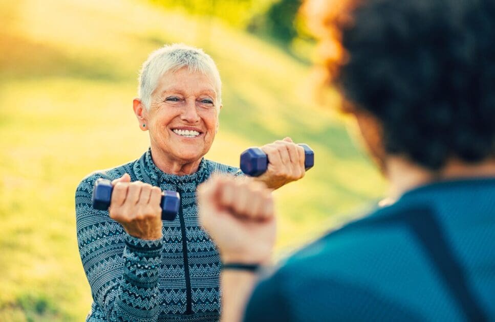 Woman lifting dumbbells during workout. Happy Menopause. Livewell Osteo. Wrist Pain Osteopath. Osteopathy for Arthritis and Joint Stiffness. Brisbane Livewell Clinic