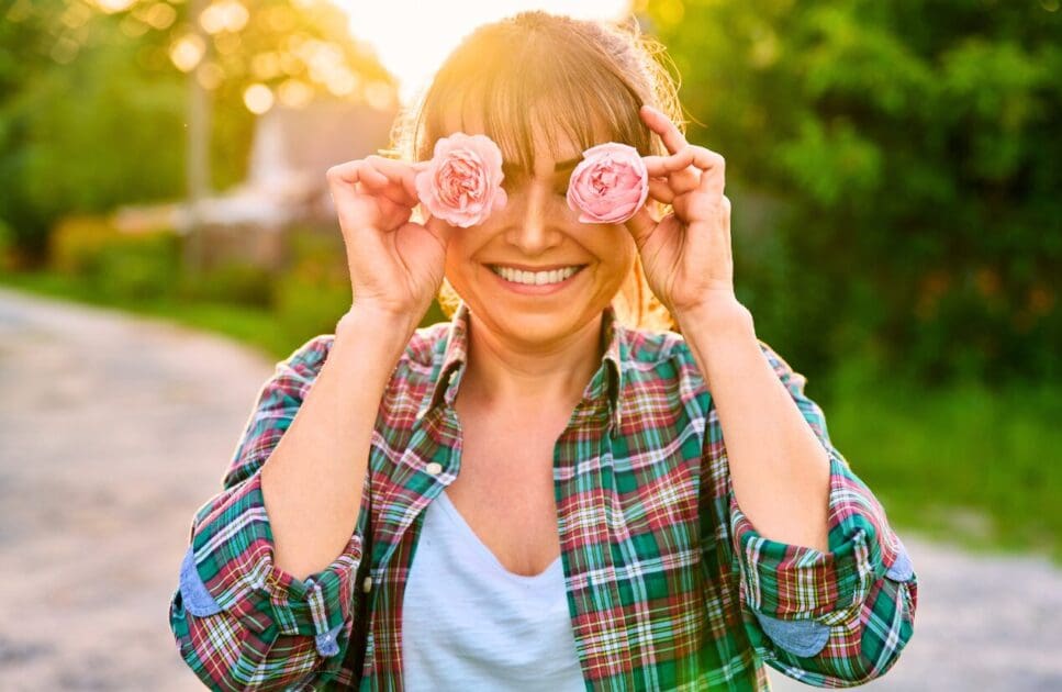 Middle-aged woman had flowers covering her eyes. Happy Menopausal Symptoms. Health Screening. Menopause Brisbane Livewell Clinic