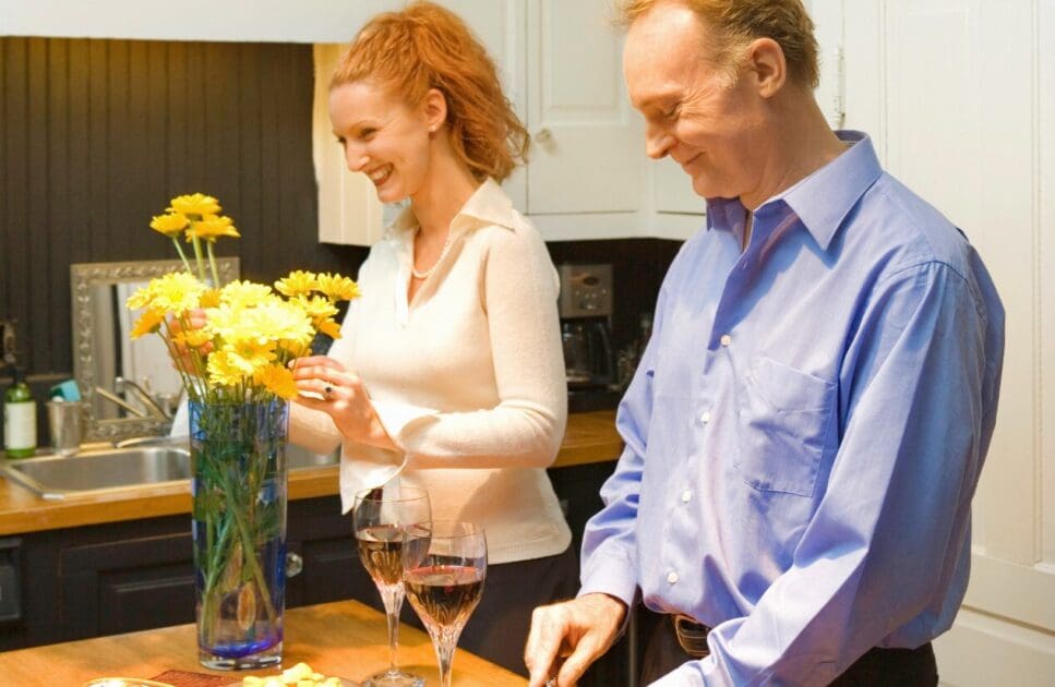 Woman arranging flowers while man prepares a meal. Mothers Day. Menopause. Brisbane Livewell Clinic
