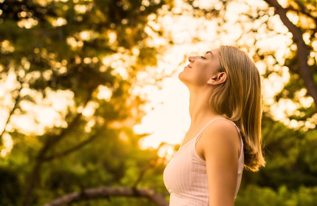 Woman standing outdoors breathing in fresh air. Clinical Hypnotherapy Morningside. Bowen Therapy in Brisbane. Chaste Tree. Brisbane Livewell Clinic