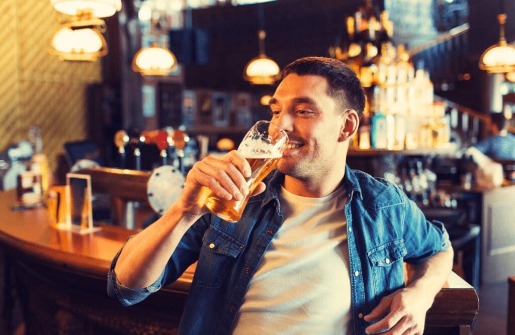 Young man drinking beer at the bar. Hypnotherapy for Alcoholism. Hypnosis and Alcoholism. Brisbane Livewell Clinic