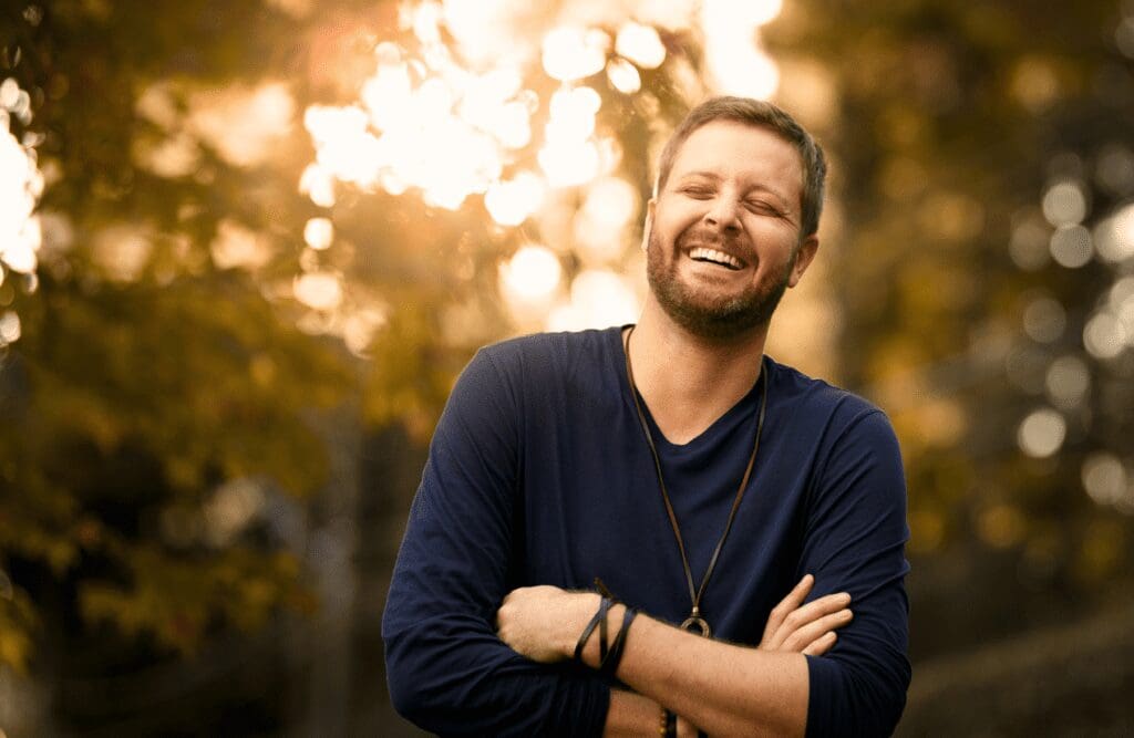 Man looks happy after knowing the benefits of hypnotherapy for alcoholism. Hypnotherapy for Alcoholism. Osteopath for Headaches. Brisbane Livewell Clinic