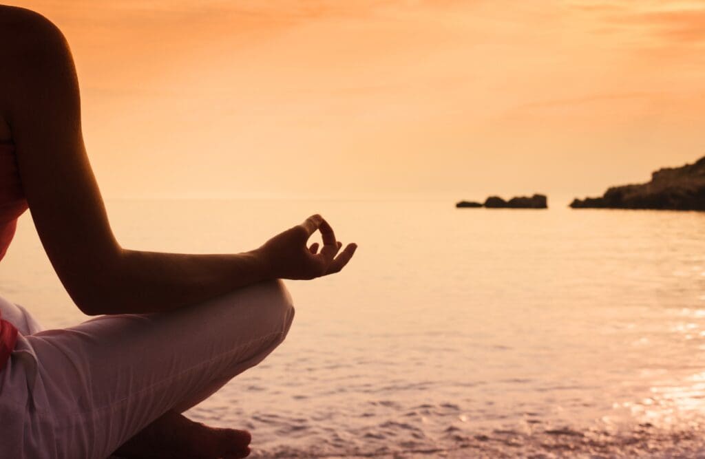 Hand of a woman meditating near the sea. Overcomering Food Intolerance. Brisbane Livewell Clinic