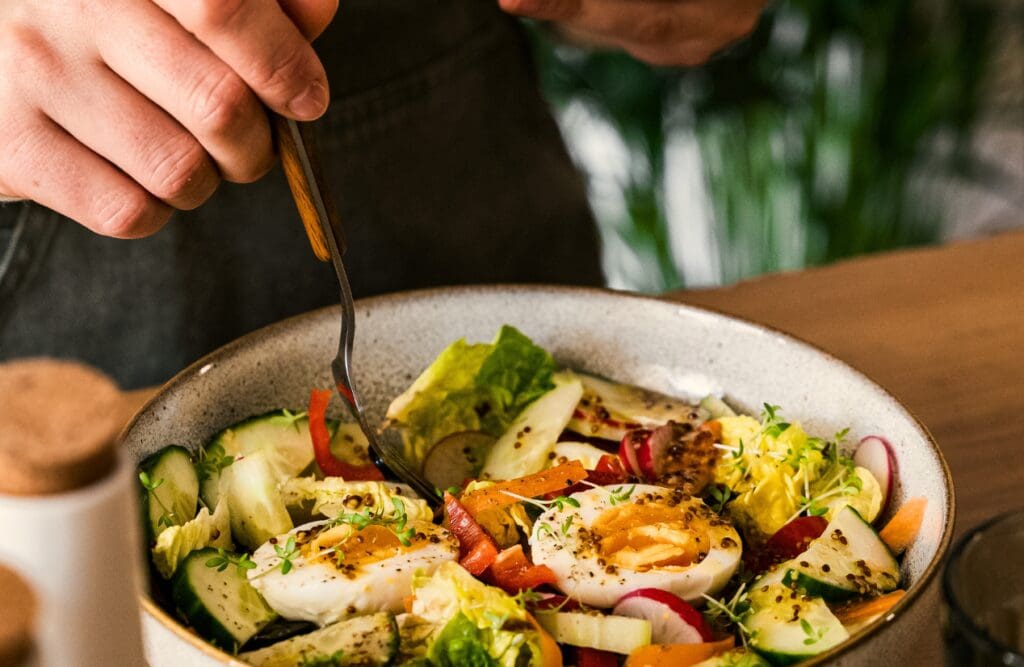A close-up of a salad bowl being prepared with a fork. Overcoming Food Intolerance. Self-Isolate. Clinical Nutritionist Seven Hills. Brisbane Livewell Clinic