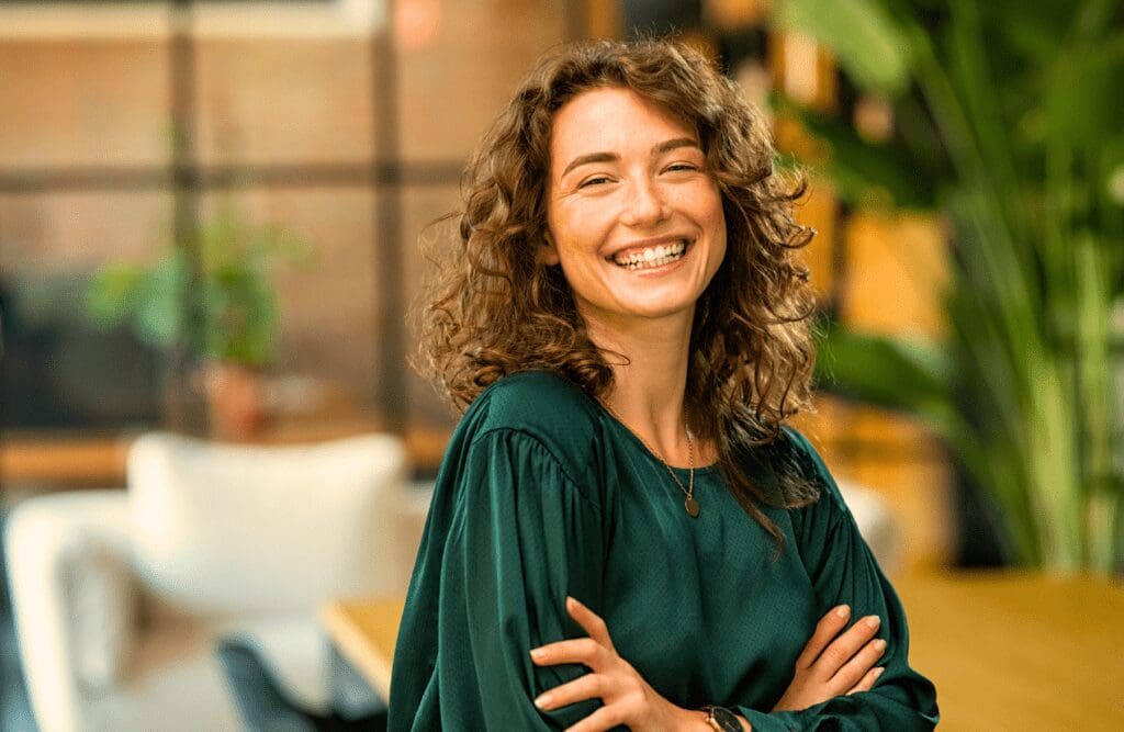 Woman smiling with crossed arms. Hypnosis in Sydney. Women's Health. Can an Osteopath Support Jaw Pain and TMJ Issues. Osteopath Neck Support and Shoulder Discomfort. Brisbane Livewell Clinic