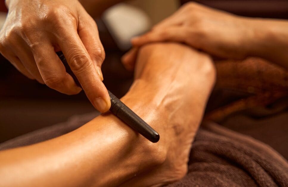 Practitioner using reflexology stick during foot reflexology. Reflexology Near Me. Massage. Brisbane Livewell Clinic