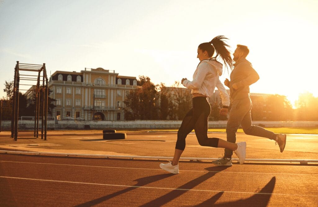 Two people jogging at the stadium. Gut brain connection. What does an Osteopath do. Brisbane Livewell Clinic