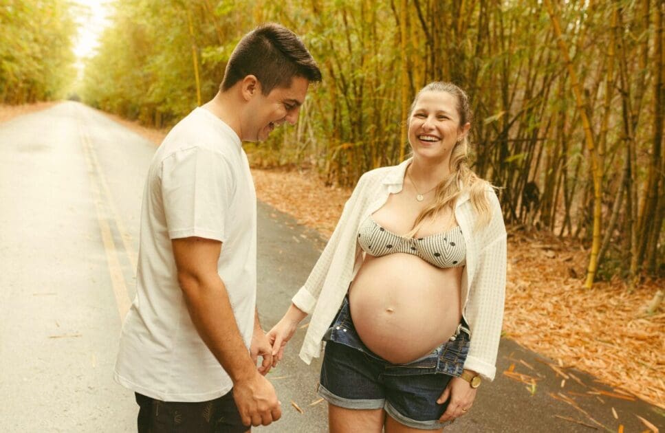 Happy pregnant couple standing on the road. Diet Planning Advice for Pregnant Woman. Prenatal Naturopath. Brisbane Livewell Clinic