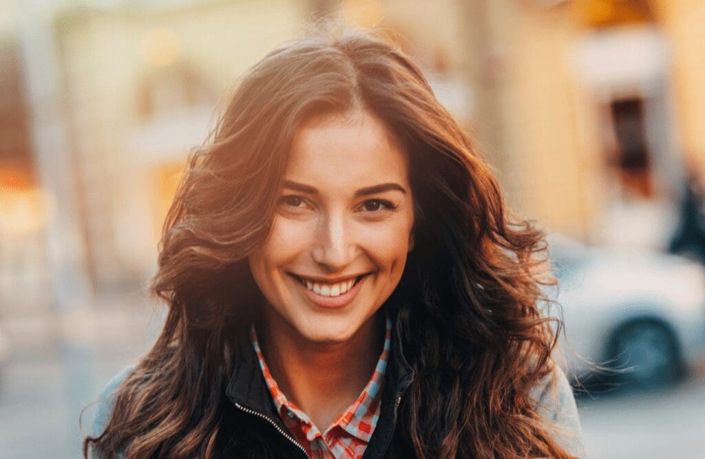 Smiling woman with long wavy hair. Hypnotherapy for Gambling. Mindset Therapy Brisbane. Brisbane Livewell Clinic. Psychosomatic Therapy