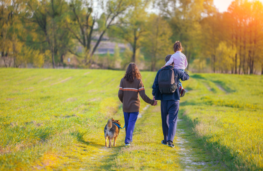 Happy family walking together with their dog. Brisbane Wellbeing. Brisbane Livewell Clinic. Osteopath Bulimba