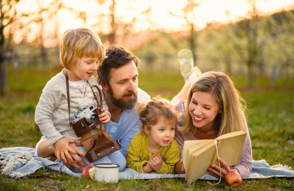 Family reading a book together in the park. Brisbane Livewell Clinic. Gut Health. Hypnotherapy Services Brisbane. Naturopath Shella Hall. Heavy Metal Detox Australia. Enhancing mental health with naturopathy. How long does it take to detox heavy metals from your body. Nathan Gurry Holistic Counselling. Hypnotherapy