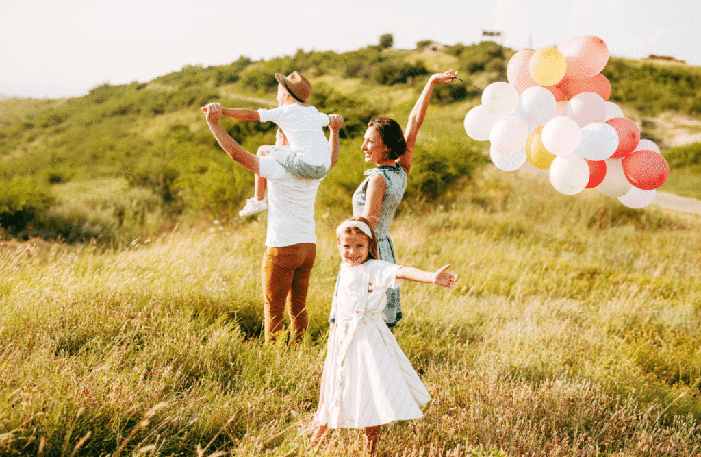 Family walking in the field, holding balloons. Children's Naturopath. Heavy Metal Detox Australia. Holistic Counselling Northgate. Brisbane Livewell Clinic