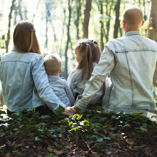 Family sitting in the bush with the man and woman holding hands together. Counselling Locations we Service at Brisbane Livewell Clinic