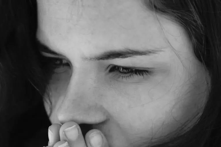 A woman holding her hand to her mouth. Do I need a parasite cleanse? Parasite cleansing