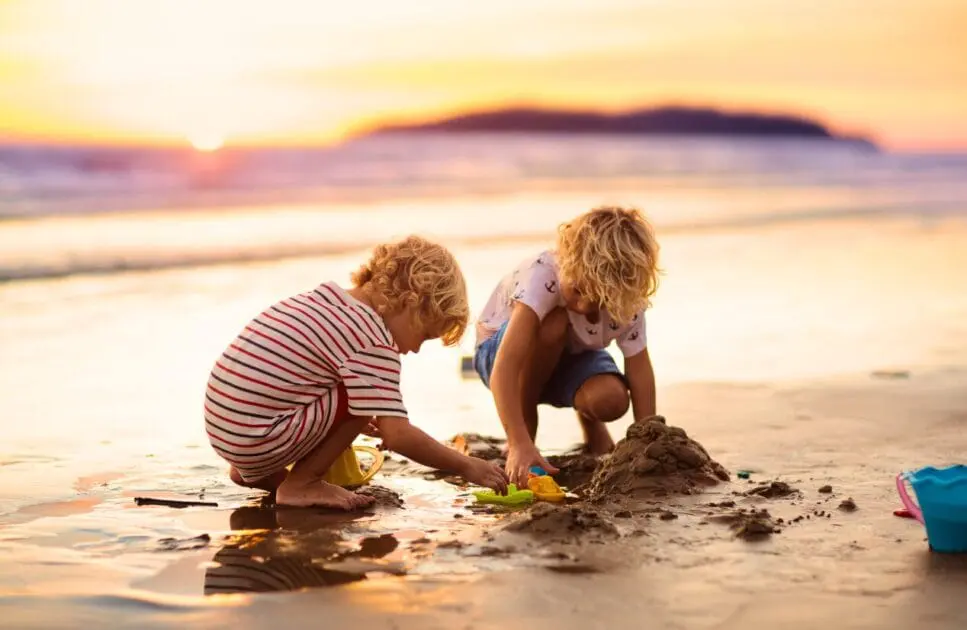 Two children building sandcastles on the beach. Counselling Norman Park. Brisbane Livewell Clinic