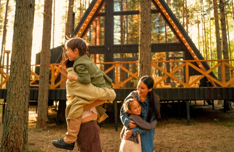 Family gathers in front of a cozy wooden cabin, smiling and enjoying their time outdoors. Hypnotherapy near Stafford Heights. Naturopathic Remedies for Insomnia. Brisbane Livewell Clinic