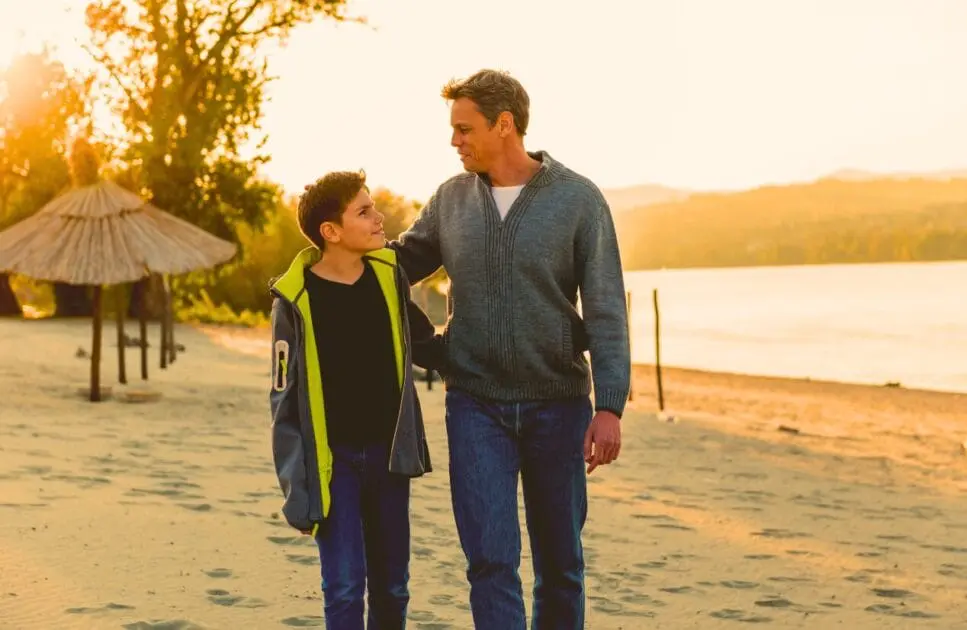 Father and son walking on the beach at sunset. Alcohol and Drug Counselling. Health Screening. Quit Vaping Hypnotherapy. Brisbane Livewell Clinic