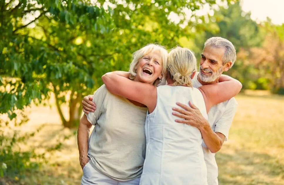 Three friends around 60 hug each other in a park. Holistic Counselling. Menopause. Naturopath Redcliffe. Counselling for Adults Who Are Tired of Pretending. Brisbane Livewell Clinic