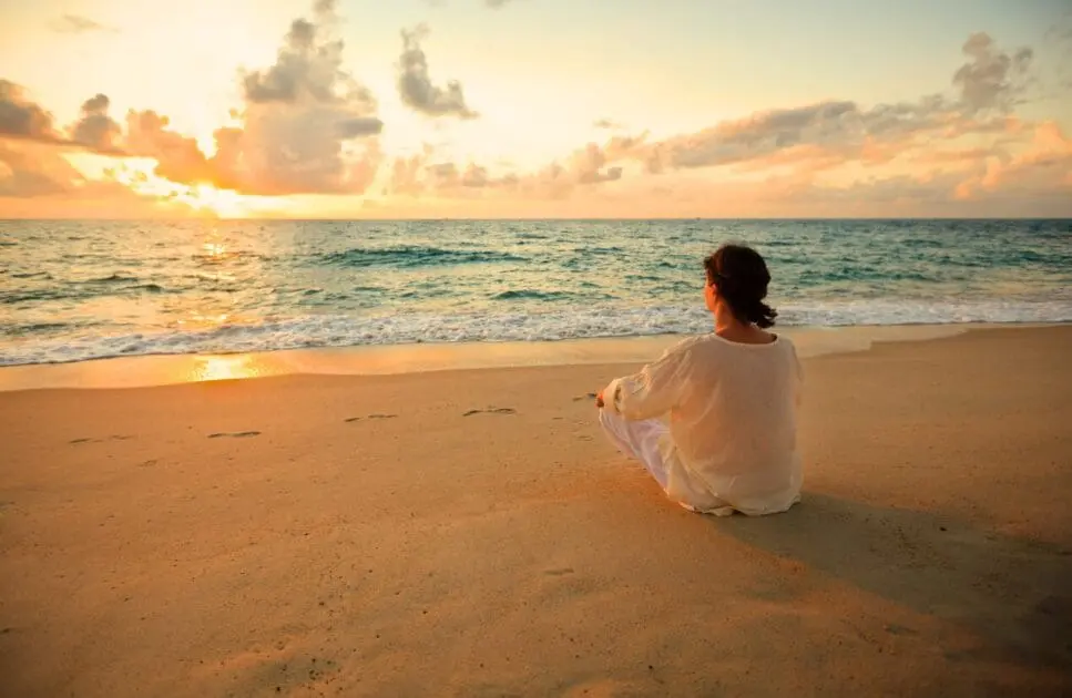 Woman sitting on the beach watching the sunset. Hormonal Imbalance. Brisbane Livewell Clinic