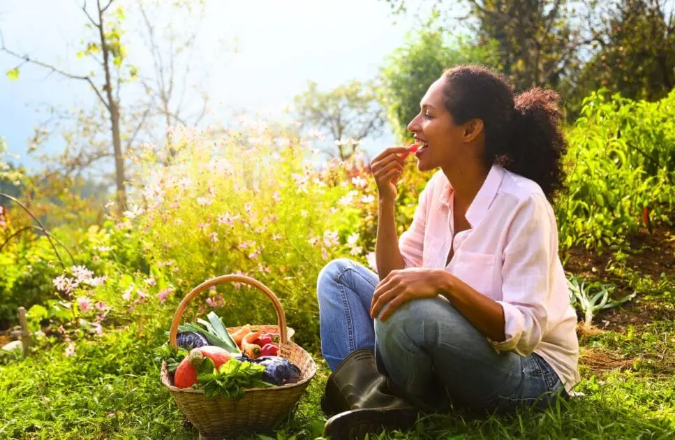 Woman eating vegetables in the garden. The Dirty Dozen. Clinical Nutritionist Morningside. Weight Loss Aids. Brisbane Livewell Clinic