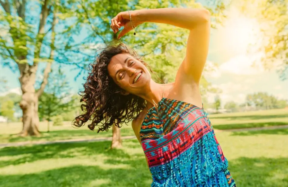 Woman dancing in the park. Treating Depression with Naturopathy. What Causes Painful Periods. Burnout Holistic Counselling. Brisbane Livewell Clinic