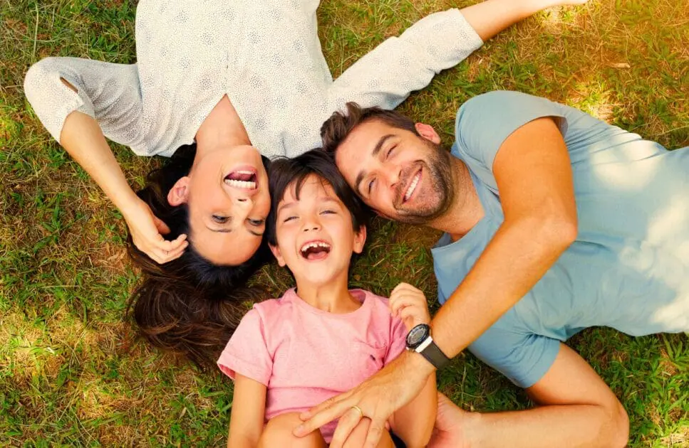 Happy family lying on the grass. Naturopathy Brisbane. Hypnosis for Weight Loss. Osteopath Near Me. Hypnotherapy to Reduce Anxiety. Brisbane Livewell Clinic