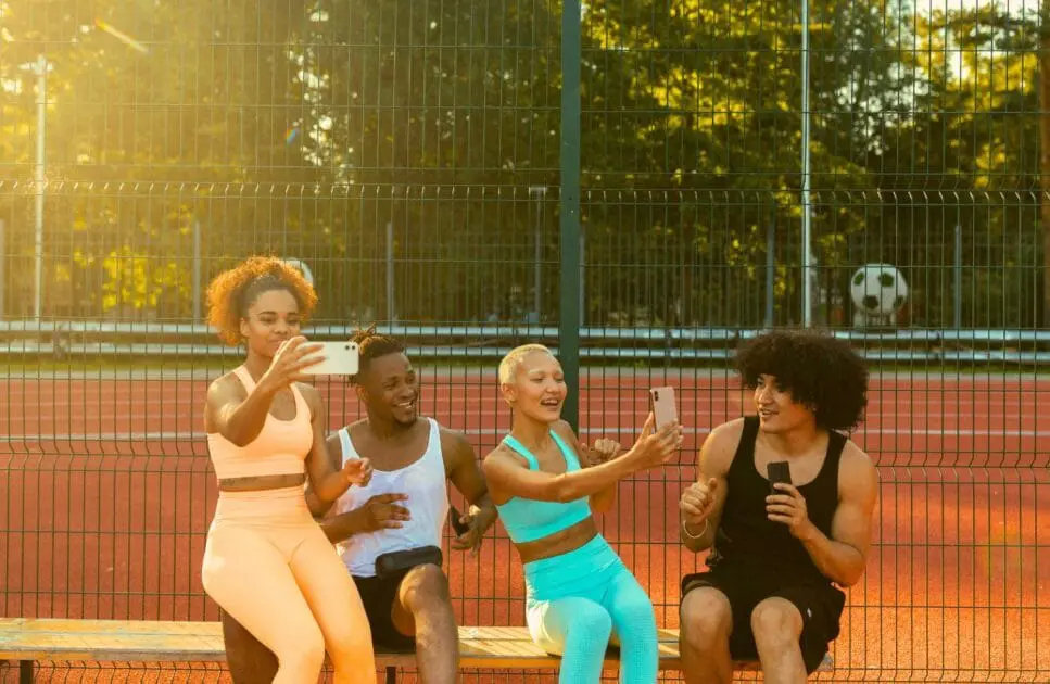 Four young individuals seated on a bench, smiling and taking a selfie together. Hypnotherapy near Clayfield. Osteopath South Brisbane. Osteopathy for Sciatic Pain and Nerve Irritation. Brisbane Livewell Clinic