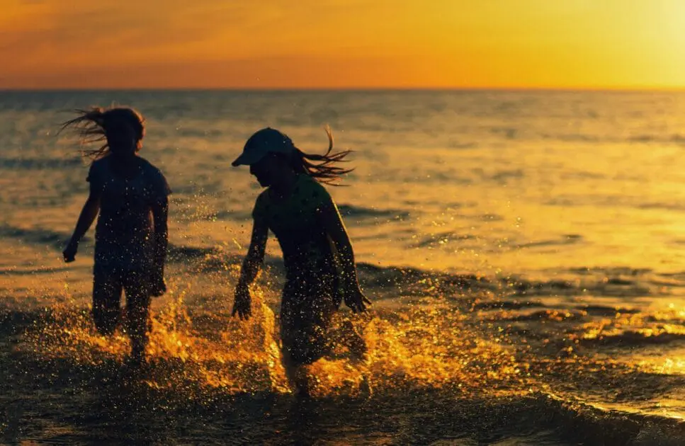 Silhouette of two kids playing in the beach at sunset. Counselling Balmoral. Counselling Northgate. Brisbane Livewell Clinic