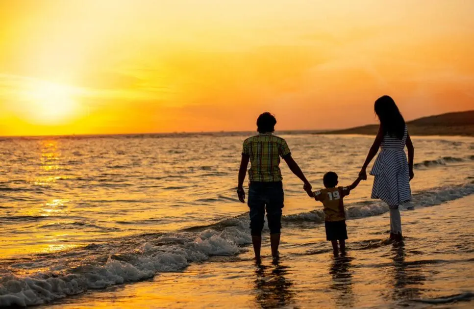 Family walking hand in hand on the beach during a beautiful sunset. Clinical Hypnotherapy. Brisbane Livewell Clinic