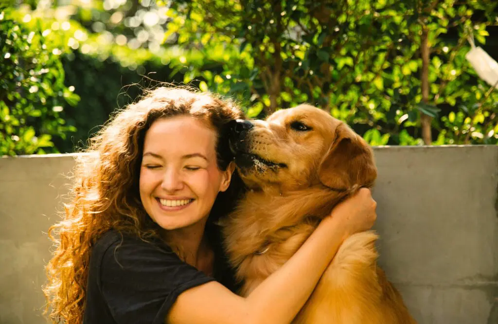 Woman hugging her golden retriever dog on the balcony. Naturopathy. Holistic Counselling Emotional Burnout. Naturopath Anxiety. Brisbane Livewell Clinic