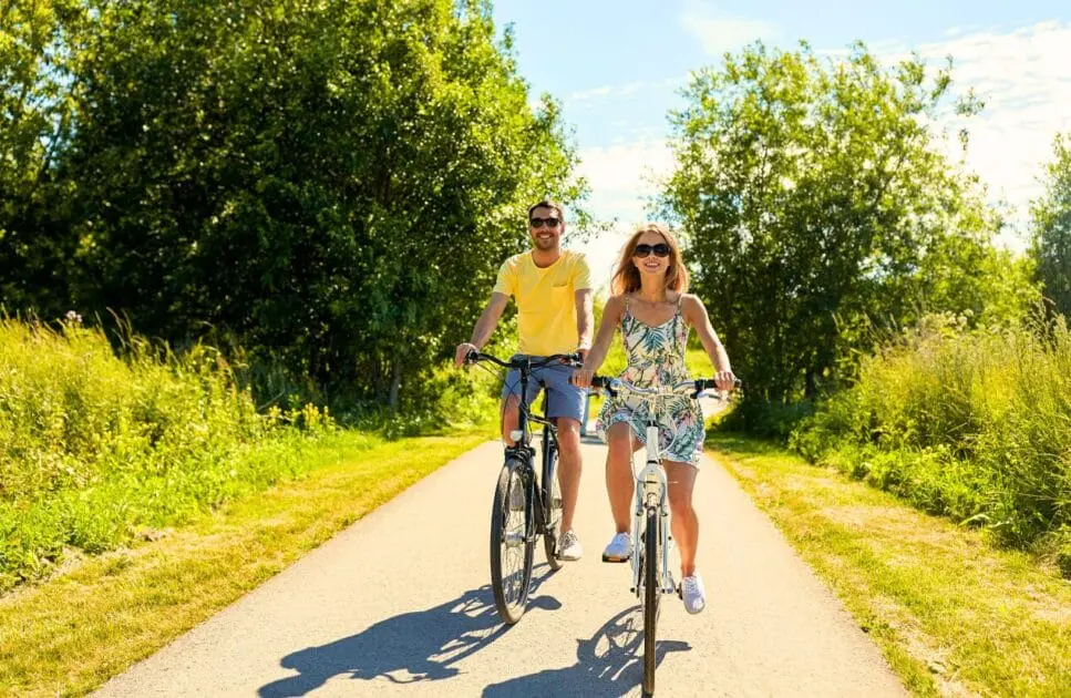 Couple riding bicycles along the road. Hypnotherapy near Kedron. Test Cortisol at Home. Osteopath Seven HIlls. Brisbane Livewell Clinic
